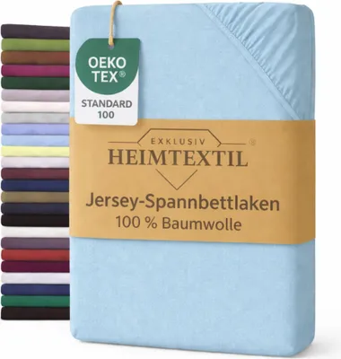 A stack of folded bed sheets in various colors is shown on the left, with a single light blue fitted sheet prominently displayed on the right, featuring a product tag and a brown band with product information.