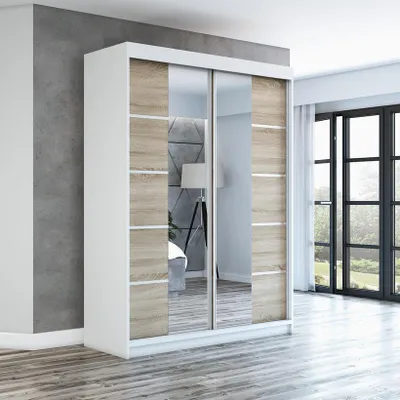 A modern wardrobe with sliding doors, featuring mirrored panels and wood-effect accents, set in a minimalist room with a grey wall and wooden floor.