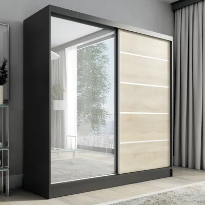 A modern sliding door wardrobe with a mirrored front and wood-effect panels, placed in a room with curtains.