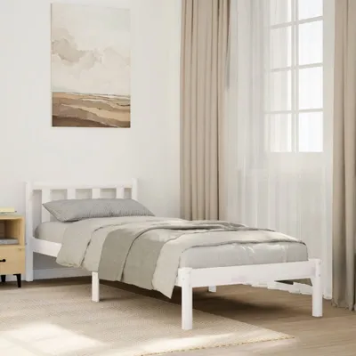 A white wooden bed frame with bedding in a bedroom setting.