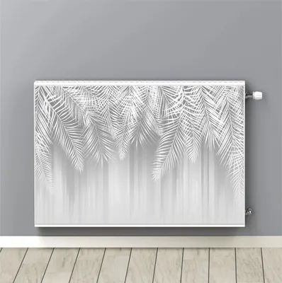 A radiator cover with a white leaf pattern is shown mounted on a gray wall above a wooden floor.
