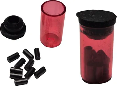 A collection of items, including a black rubber gasket, a red plastic tube, a pile of black cylindrical objects, and a red plastic tube filled with black cylindrical objects and sealed with a black cap.