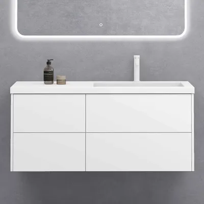 A white wall-mounted vanity with a sink and faucet against a gray wall.