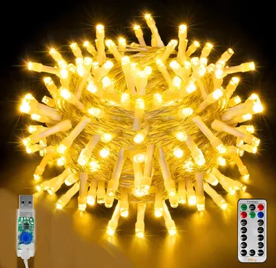 A close-up, studio shot of a large bundle of yellow LED string lights, with a USB connector and a remote control visible in the foreground.