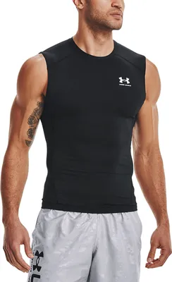 A man wearing a black sleeveless fitness t-shirt and grey shorts.
