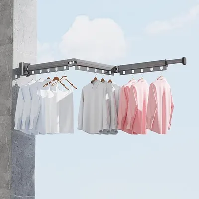 A wall-mounted retractable clothes drying rack with clothes hanging on it, set against a sky background.