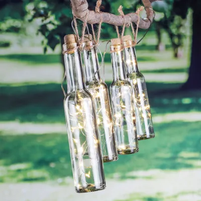 Produktbild von Spetebo Solar LED Lichterkette für Garten mit 48 warmweißen LEDs in 4 transparenten Glas & Kunststoff Flaschen. Maße: Flasche 24,5x5 cm, 7m Zuleitung, 50 cm Abstand. Batterie: AA 1.5V LR6.