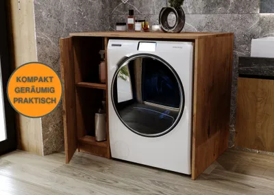 A washing machine is housed within a wooden cabinet in a bathroom setting.