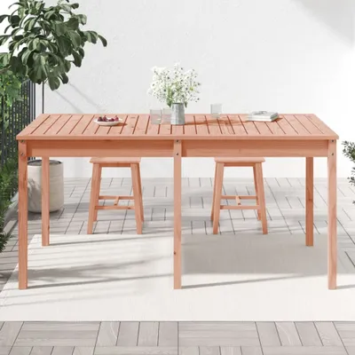 An outdoor patio scene with a wooden table and stools.