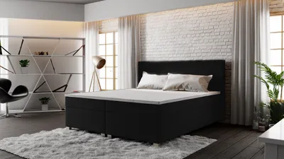 A bedroom setting with a bed, bookshelf, and chair.