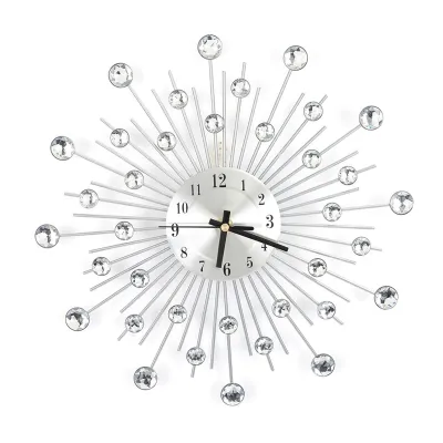 A decorative wall clock with a sunburst design and crystal accents, displayed against a white background.