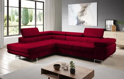 A modern living room with a large red sectional sofa, a coffee table, and artwork on the wall.