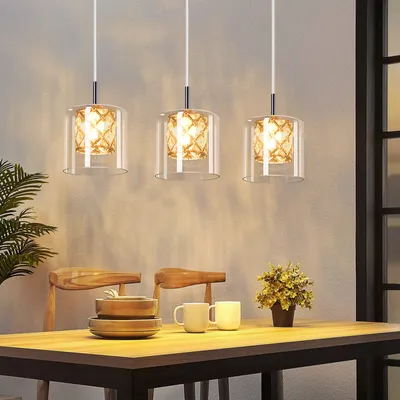 A dining table set with pendant lights hanging above.