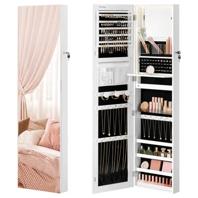 A white jewelry cabinet with a mirrored door is shown open, revealing its interior storage compartments filled with jewelry and cosmetics. The left side of the image shows a reflection of a bedroom with pink curtains and pillows.