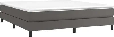 A grey boxspring bed with a white mattress.
