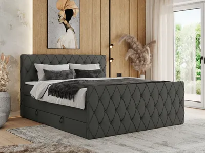 A bedroom scene featuring a large upholstered bed with storage drawers, set against a wood-paneled wall with artwork and decorative elements.