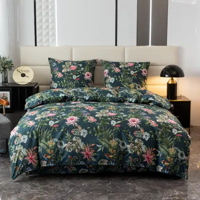A neatly made bed with a floral patterned duvet and pillows, set against a headboard and bedside tables with a lamp and clock.