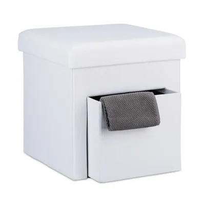 A white storage ottoman with a gray towel hanging from a side compartment.