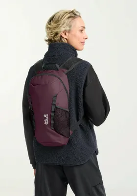 A woman wearing a black fleece vest and black top is shown from the back, wearing a burgundy backpack.