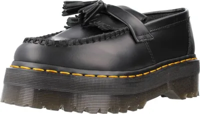 A studio shot of a black leather loafer with a platform sole and tassels.