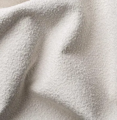 A close-up view of a textured, light-colored fabric, likely upholstery.