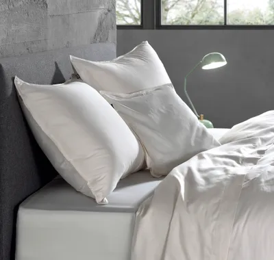A bed with pillows and a lamp.