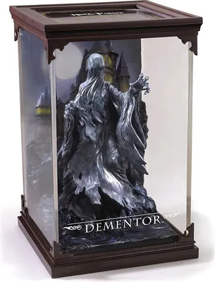 A Dementor figurine in a display case with a castle and moon background.