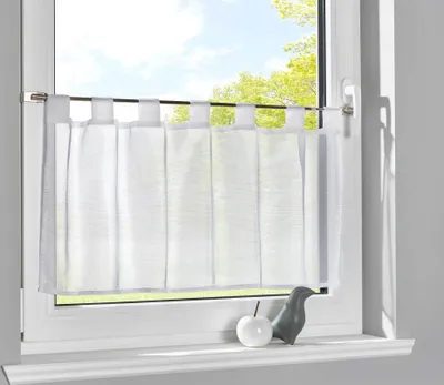 A white sheer curtain hangs on a window rod, covering the lower half of a window. A small white apple and a gray bird figurine sit on the windowsill below.