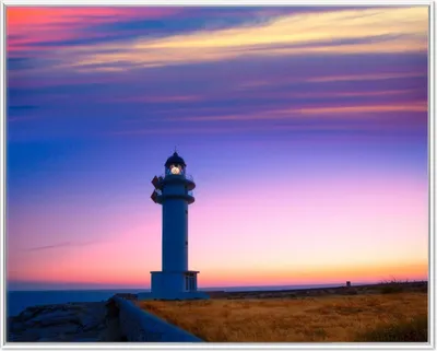 Produktbild von Wallario Wandbild Leuchtturm am Abend auf den Balearen Malerischer Himmel, Größe: 40,30 x 50,30 cm, Poster mit weißem Aluminiumrahmen