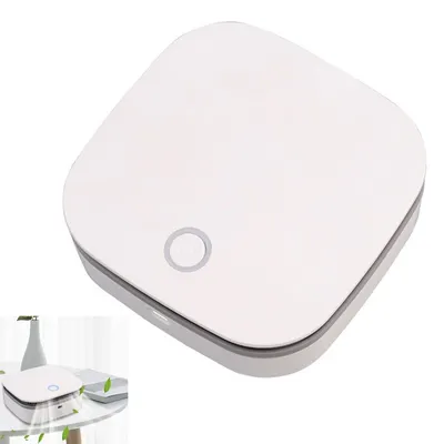 A white, square-shaped air purifier with a circular button on top, placed on a white surface.