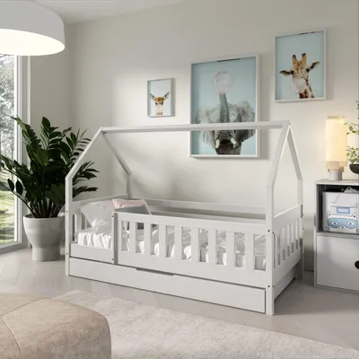 A child's bedroom with a white house-shaped bed, plants, and artwork on the wall.