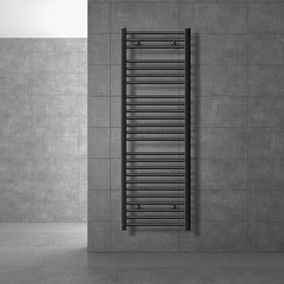 A dark anthracite radiator is mounted on a gray tiled wall in a modern bathroom.
