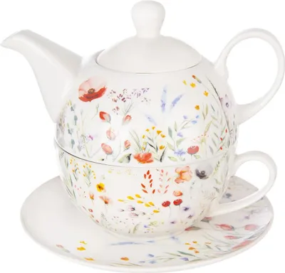 A white porcelain teapot and cup set with a floral pattern, placed on a matching saucer.