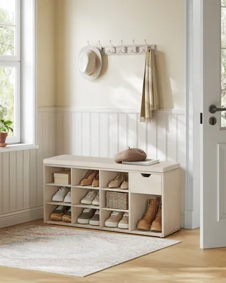 A shoe bench with storage in a hallway next to a window and a door.