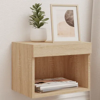A wall-mounted nightstand with a plant and framed picture on top, and magazines inside the shelf.