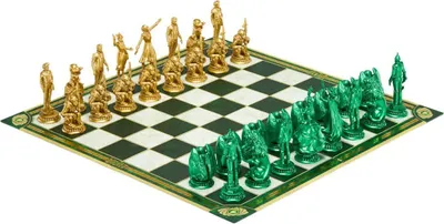 A chess set with gold and green pieces arranged on a chessboard.
