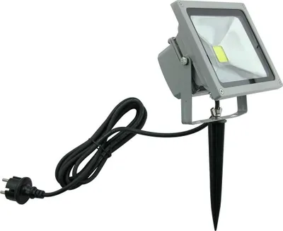 A garden spotlight with a stake and power cord, isolated on a white background.