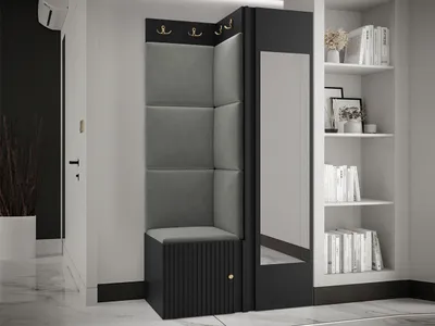 A corner entryway set with a bench, coat hooks, and a mirror, next to a bookshelf.