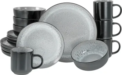 A collection of stoneware dinnerware, including plates, bowls, and mugs, arranged on a white background.