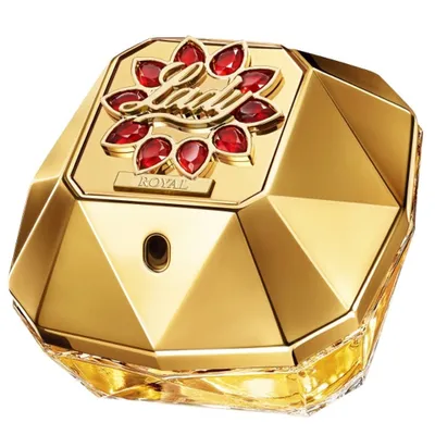 A close-up studio shot of a golden perfume bottle with red gem accents.