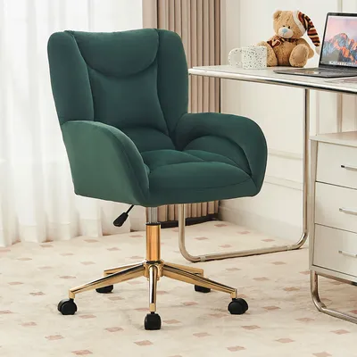 A green velvet office chair with a gold metal base is shown in a room with a desk and a teddy bear.