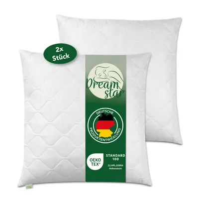 Two white quilted pillows are shown, with a green label attached to the front pillow.