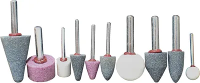 A collection of grinding stones with metal shafts, arranged in a line against a white background.