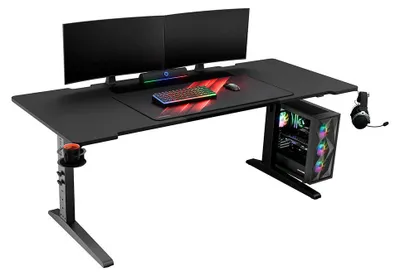 A gaming desk setup with dual monitors, keyboard, mouse, and a computer tower.