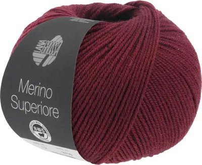 A ball of burgundy yarn with a label.