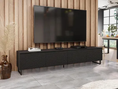 A modern living room with a TV mounted on a wood-paneled wall above a black TV stand.