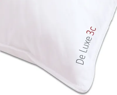 A close-up view of a white pillow with text printed on the corner.