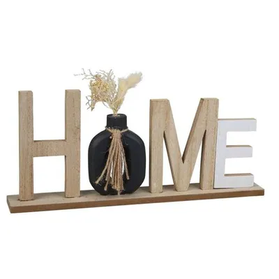 A wooden decorative sign spelling out "HOME" with a small black vase holding dried flowers in place of the letter 'O'. The sign is on a white background.