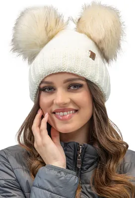 A woman wearing a winter hat with two pom-poms.