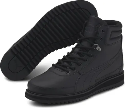 A pair of black Puma boots shown from a diagonal angle, with one boot standing and the other lying on its side to show the sole.